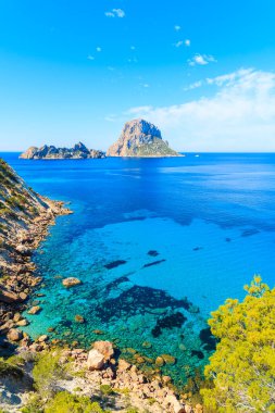 Güzel mavi deniz suyuyla Cala d 'Hort Körfezi manzarası ve İbiza Adası, İspanya' da Es Vedra adası.