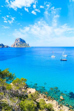 Güzel mavi deniz suyuyla Cala d 'Hort Körfezi manzarası ve İbiza Adası, İspanya' da Es Vedra adası.