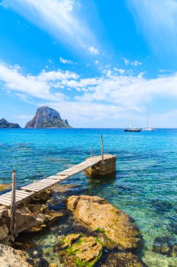 Cala d 'Hort körfezindeki küçük ahşap iskele ve Es Vedra Adası, İbiza Adası, İspanya manzarası.