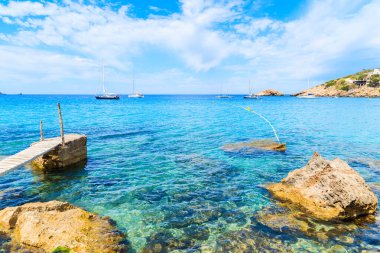 Cala d 'Hort körfezindeki küçük ahşap iskele ve Es Vedra Adası, İbiza Adası, İspanya manzarası.