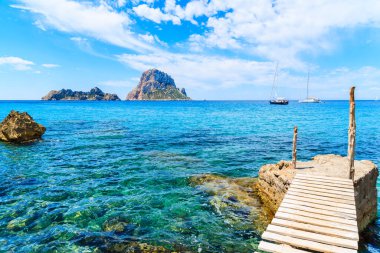 Cala d 'Hort körfezindeki küçük ahşap iskele ve Es Vedra Adası, İbiza Adası, İspanya manzarası.