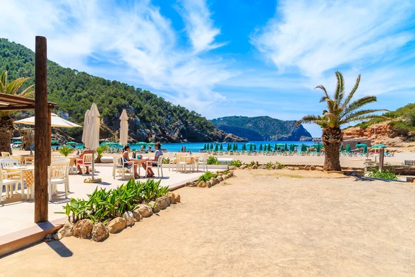 CALA BENIRRAS BEACH, IBIZA ADASI - 16 Mayıs 2017: Cala Benirras plajı, İbiza adası, İbiza 'daki terasta restoran masasında oturan bir sürü insan.
