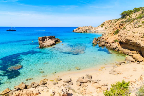 İspanya 'nın İbiza adasında turkuaz deniz suyunda kayalıklı Cala Tarida Körfezi manzarası