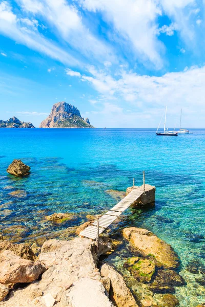 Cala d 'Hort körfezindeki küçük ahşap iskele ve Es Vedra Adası, İbiza Adası, İspanya manzarası.