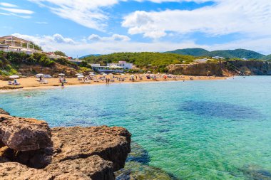 Ibiza Adası, İspanya 'da güneşlenen turistlerin olduğu kumlu Es Figueral plajı manzarası