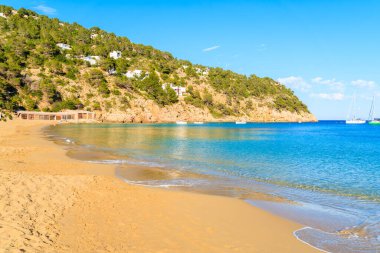 Kumsal ve sakin deniz suyu Cala San Vicente koyunda güneşli yaz gününde, İbiza adası, İspanya