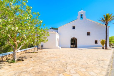 İspanya 'nın İbiza adasının kuzey kesimindeki Sant Vicent de sa Cala köyünde tipik beyaz kilisesi olan meydan.