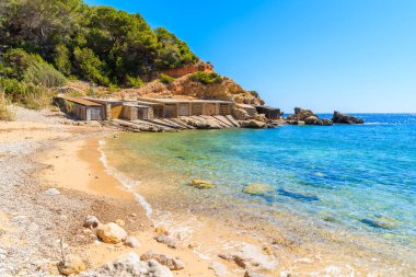 İspanya 'nın İbiza adasındaki kayıkhaneli tenha Cala d' en Serra plajı manzarası.