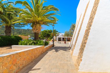 İspanya 'nın İbiza adasındaki Es Cubell köyündeki tipik beyaz kilise ve palmiye ağaçları