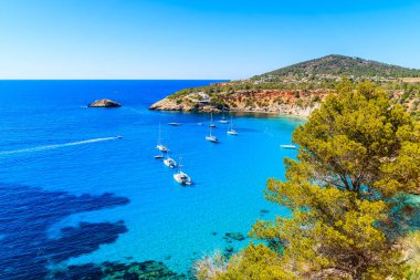 Cala d 'Hort körfezi manzarası güzel mavi deniz suyunda yelkenli tekneler, İbiza adası, İspanya