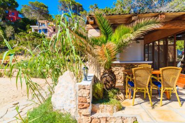 CALA CARBO, IBIZA Adası- 19 Mayıs 2017: İspanya 'nın İbiza adasındaki Cala Carbo plajındaki tropikal bahçede küçük bir bar.