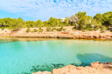 Sabahın erken saatlerinde kristal berrak deniz suyuyla güzel Cala Gracioneta Körfezi manzarası, İbiza Adası, İspanya