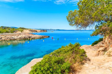 Sabahın erken saatlerinde İspanya 'nın İbiza adasında güzel Cala Gracio körfezi boyunca uzanan kıyı yolu manzarası.