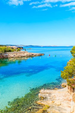 İspanya 'nın İbiza adasında sabahın erken saatlerinde gök mavisi deniz suyuyla güzel Cala Gracio Körfezi manzarası