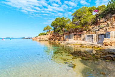 Sabahın erken saatlerinde İspanya 'nın İbiza adasında kıyıda kayıkhaneleri olan güzel Cala Gracio plajı manzarası.