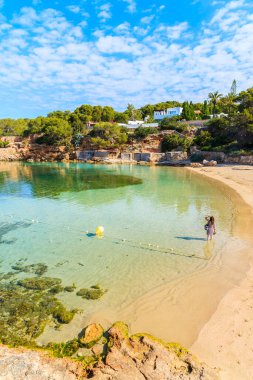 Sabahın erken saatlerinde İspanya 'nın İbiza adasında, güzel Cala Gracio plajında suda duran kimliği belirsiz bir kadın.