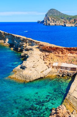 Punta Galera Körfezi 'ndeki kayıkhaneler İbiza Adası, İspanya' daki inanılmaz taş oluşumlarıyla çevrili.