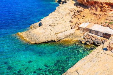 Punta Galera Körfezi 'ndeki kayıkhaneler İbiza Adası, İspanya' daki inanılmaz taş oluşumlarıyla çevrili.
