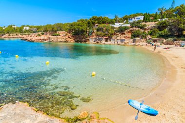İspanya, İbiza 'daki güzel Cala Gracioneta plajında mavi bir kano.