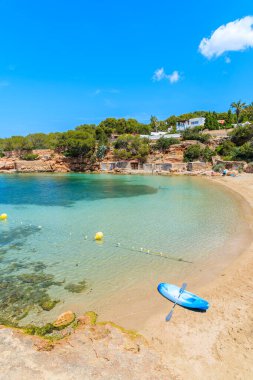 İspanya, İbiza 'daki güzel Cala Gracioneta plajında mavi bir kano.