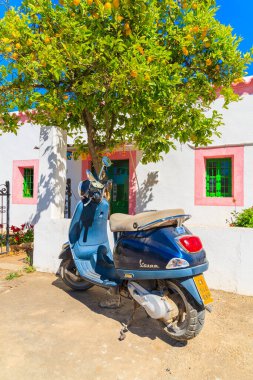 IBIZA Adaları, İspanya - 18 Mayıs 2017: Klasik Vespa scooter park yeri Limon ağacı ve geleneksel beyaz ev Sant Carles de Peralta köyü, İspanya.