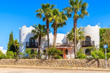 IBIZA Adaları, İspanya - 20 Mayıs 2-17: Lüks beyaz tatil köşkü ve İspanya 'nın İbiza adasının Cala Nova bölgesindeki bahçedeki yüksek palmiye ağaçları.