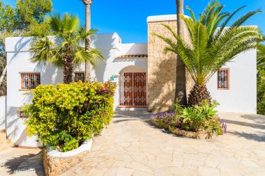 IBIZA Adaları, İspanya - 20 Mayıs 2-17: İspanya 'nın İbiza Adası' nın Cala Nova bölgesindeki bahçedeki beyaz renkli tatil villası ve palmiye ağaçları.