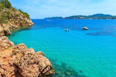 İspanya, İbiza 'daki Cala San Vicente Körfezi' ndeki kayalar ve gök mavisi deniz.