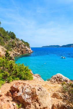 İspanya, İbiza 'daki Cala San Vicente Körfezi' ndeki kayalar ve gök mavisi deniz.