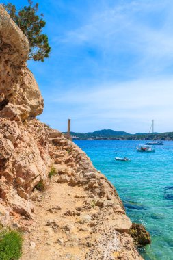 İspanya 'nın İbiza adası Cala San Vicente Körfezi' ndeki kayalıklar ve kayıklar.