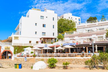 CALA PORTINATX BAY, IBIZA ADASI - 22 Mayıs 2017: Güneşli yaz gününde Cala Portinatx Koyu 'ndaki otel ve restoran binaları, İbiza Adası, İspanya.