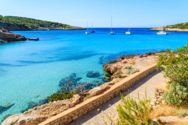 İspanya 'nın İbiza adasındaki Cala Portinatx Körfezi' ndeki mavi deniz boyunca uzanan kıyı şeridi manzarası