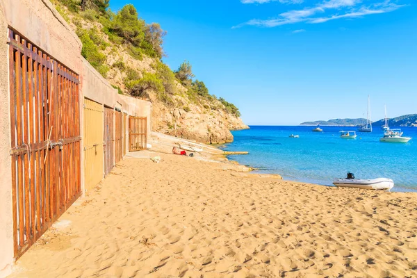 İspanya, İbiza 'daki Cala San Vicente Körfezi' ndeki kumlu sahilde kayıkhaneler.