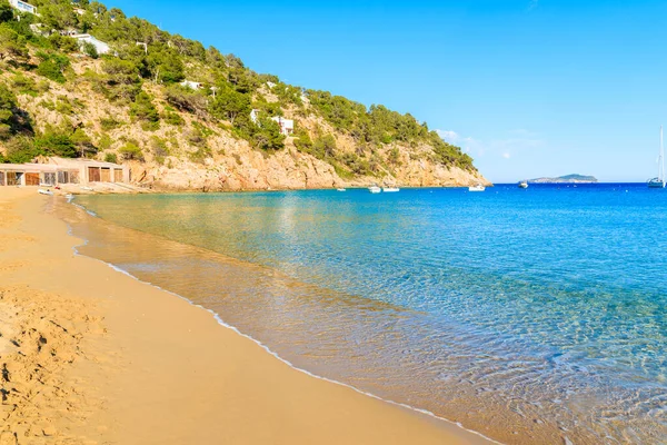 Kumsal ve sakin deniz suyu Cala San Vicente koyunda güneşli yaz gününde, İbiza adası, İspanya