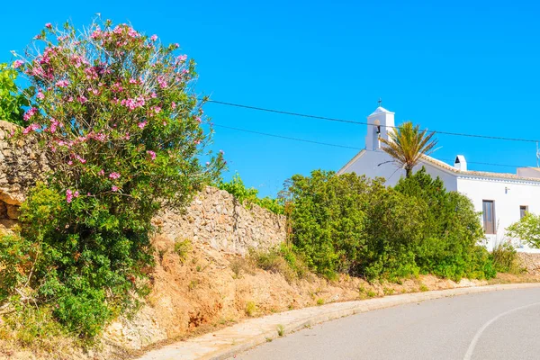 İspanya 'nın İbiza adasının kuzey kesimindeki Sant Vicent de sa Cala köyündeki yol ve beyaz tipik kilise