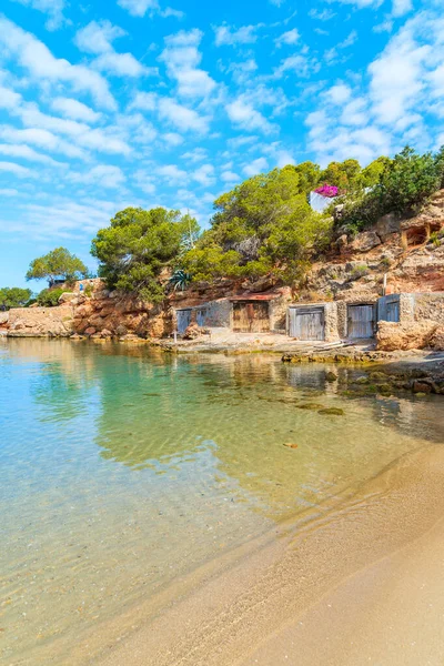 Sabahın erken saatlerinde İspanya 'nın İbiza adasında kıyıda kayıkhaneleri olan güzel Cala Gracio plajı manzarası.