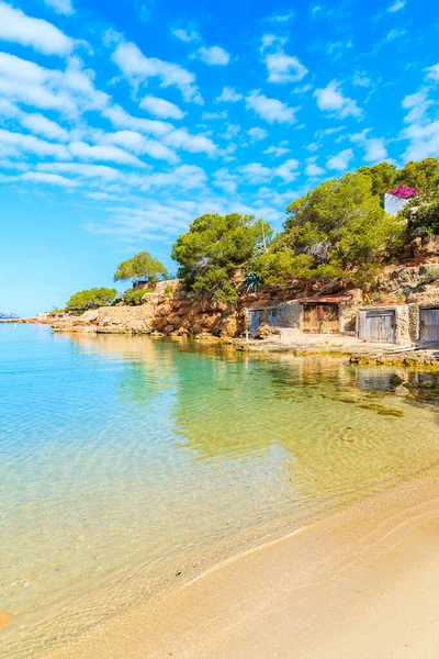 Sabahın erken saatlerinde İspanya 'nın İbiza adasında kıyıda kayıkhaneleri olan güzel Cala Gracio plajı manzarası.