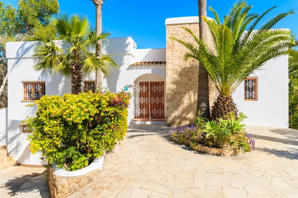 IBIZA Adaları, İspanya - 20 Mayıs 2-17: İspanya 'nın İbiza Adası' nın Cala Nova bölgesindeki bahçedeki beyaz renkli tatil villası ve palmiye ağaçları.