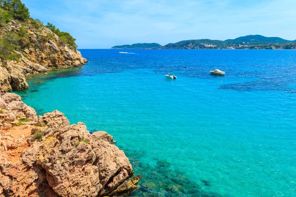 İspanya, İbiza 'daki Cala San Vicente Körfezi' ndeki kayalar ve gök mavisi deniz.