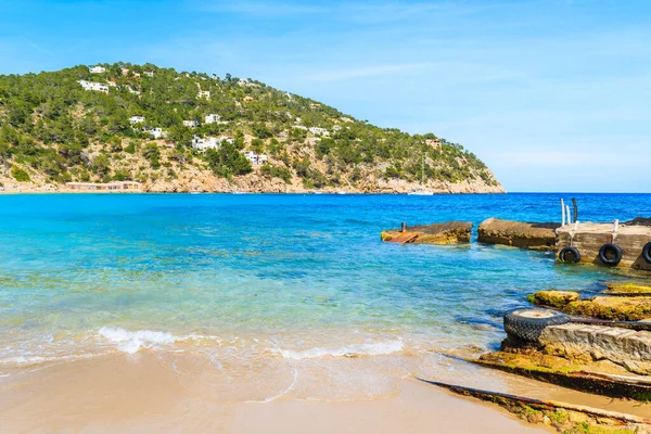 İspanya, İbiza 'daki Cala San Vicente plajının gök mavisi suyu.