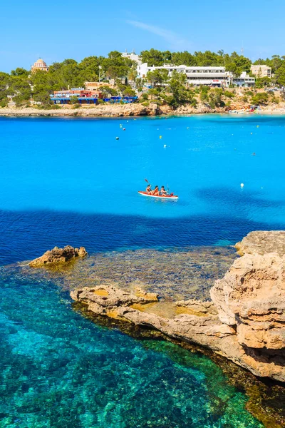 IBIZA Adaları, İspanya - 22 Mayıs 2017: İspanya 'nın İbiza adası Cala Portinatx Koyu' nun mavi deniz suyunda kano süren turistler.