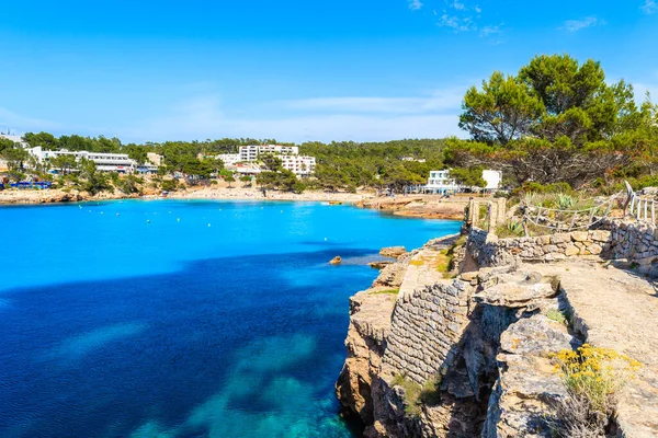 İspanya 'nın Ibiza adasında, Cala Portinatx' ın güzel körfezinde, masmavi deniz boyunca uzanan kıyı yolu.