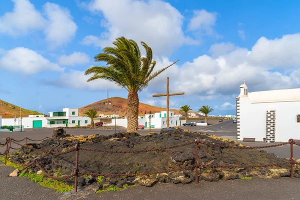 Palm tree and typical white church in Tinajo village near Timanfya National Park — Stock Photo, Image