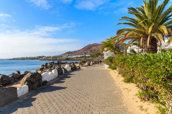 Strandpromenad med tropiska växter i Playa Blanca semesterstad — Stockfoto