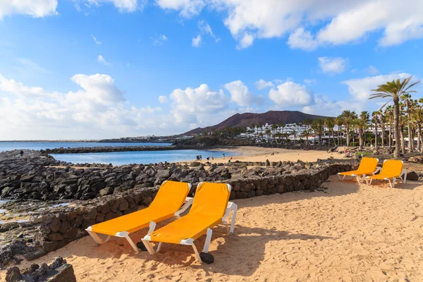 Camas de sol na praia vulcânica Playa Blanca — Fotografia de Stock