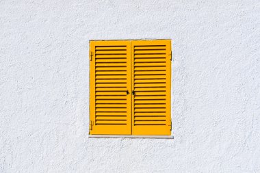 Sarı pancurlar ve beyaz duvar