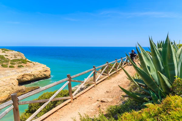 Turistas en el camino del acantilado a lo largo del mar observando hermoso mar — Foto de Stock