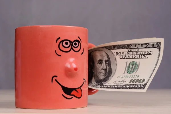 Cup with dollars money in the hand — Stock Photo, Image