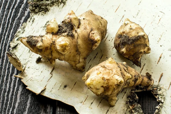 Fresh jerusalem artichokes on birch bark — Stock Photo, Image