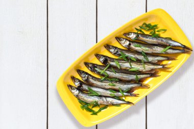 Capelin sarı plaka üzerinde yeşil soğan ile füme 